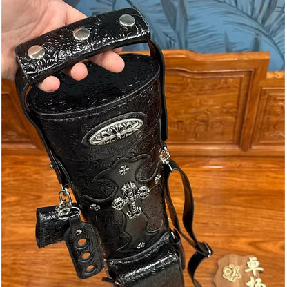 Black leather glove with silver studs and designs on a wooden surface