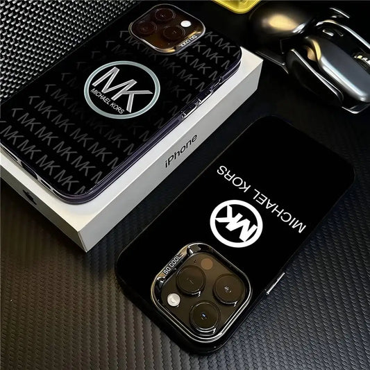 Two phone cases with Michael Kors logo on a textured surface