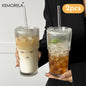 Two glass tumblers with drinks held by a person, featuring KEMORELA branding.