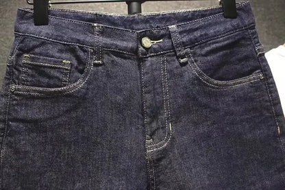 Close-up of dark blue jeans with a focus on the waistband and pockets.