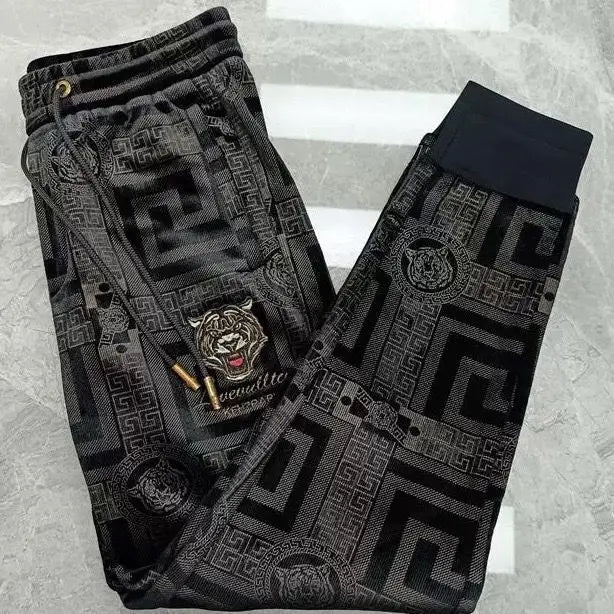 Black patterned pants with a brand logo on a gray background