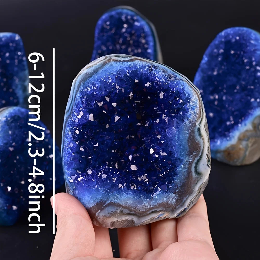 Blue crystal geode held in hand with size measurement on a black background