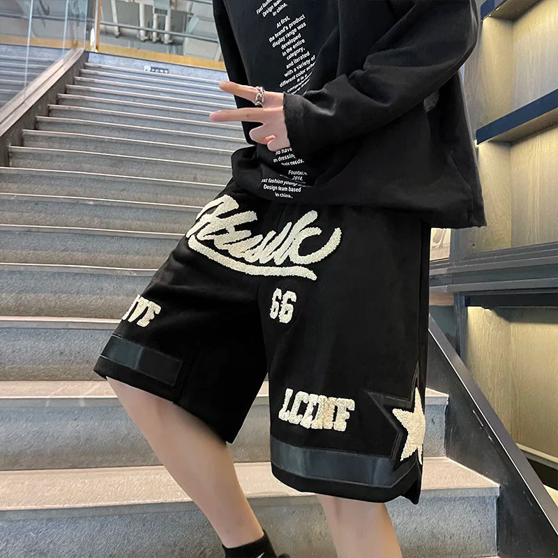 Person wearing a black outfit with white text and logos on stairs