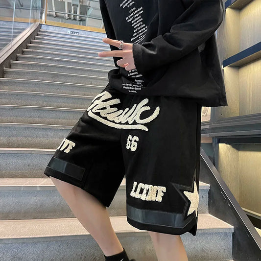 Person wearing a black outfit with white text and logos on stairs