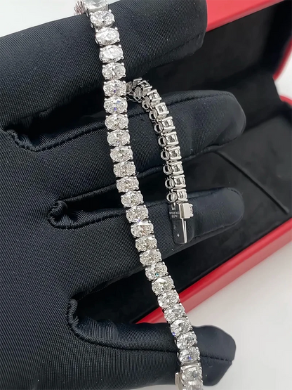 Diamond bracelet held by a gloved hand with a red box in the background