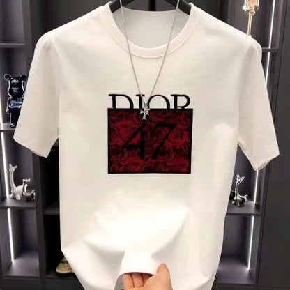 White t-shirt with Dior logo and red design held by a hand against a dark background.