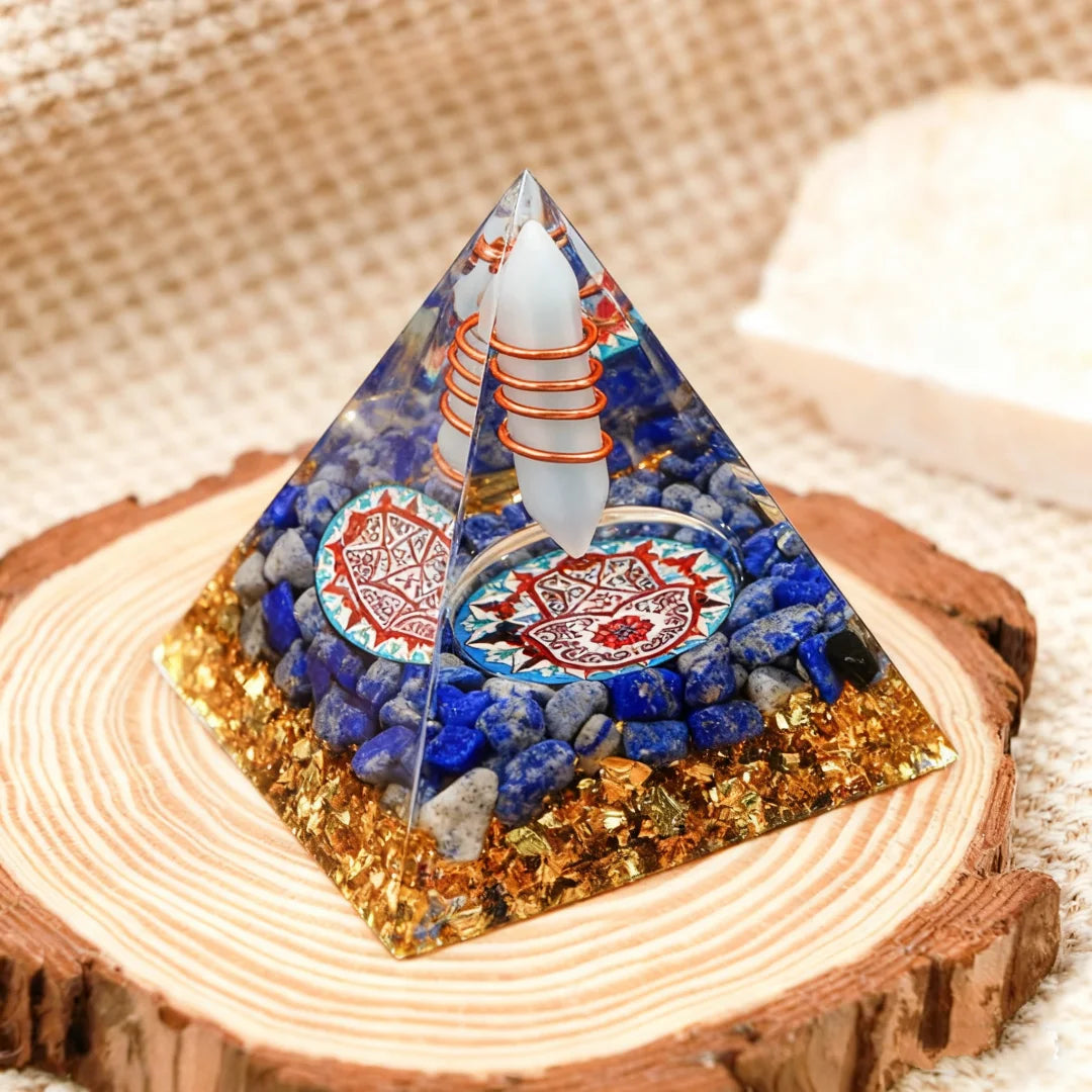 Pyramid-shaped crystal with decorative elements on a wooden base