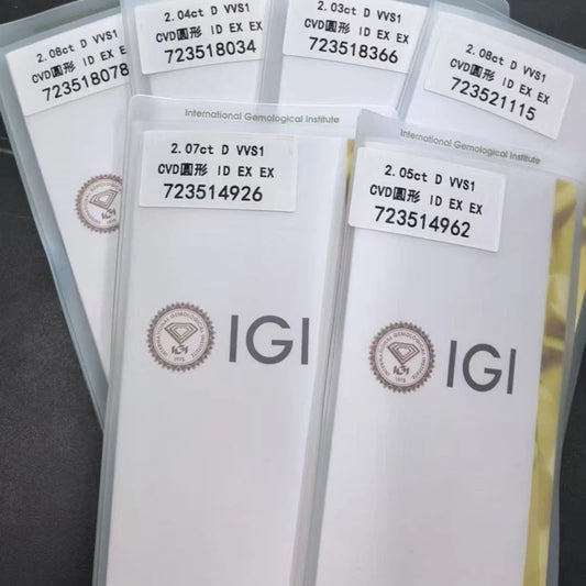 Several white IGI gemstone certificate envelopes fanned out on a dark surface, each with a white label showing text such as '2.04ct D VVS1' and 'International Gemological Institute'.