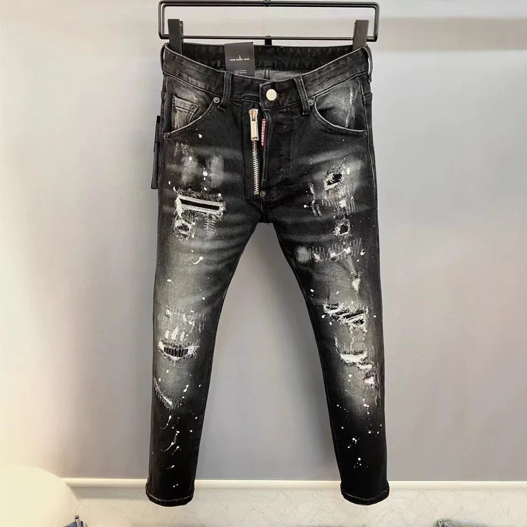 Black distressed jeans on a hanger against a plain background