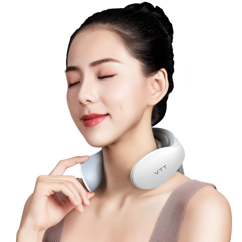 Woman wearing a white neck massager with a neutral background
