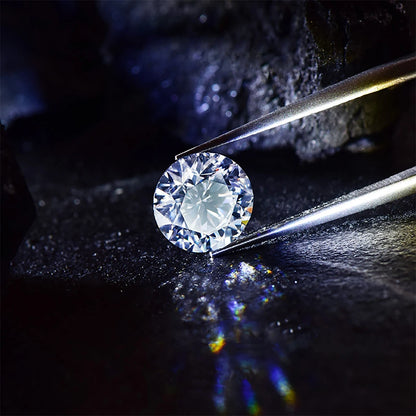 Diamond held by tweezers on a dark background