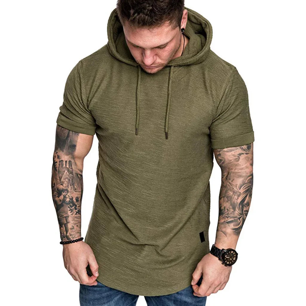 Man wearing a green hoodie with tattoos on his arms against a white background