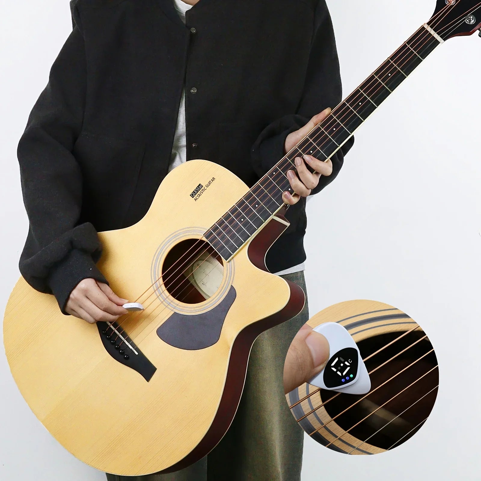 Person holding an acoustic guitar with a close-up of a digital tuner on a white background