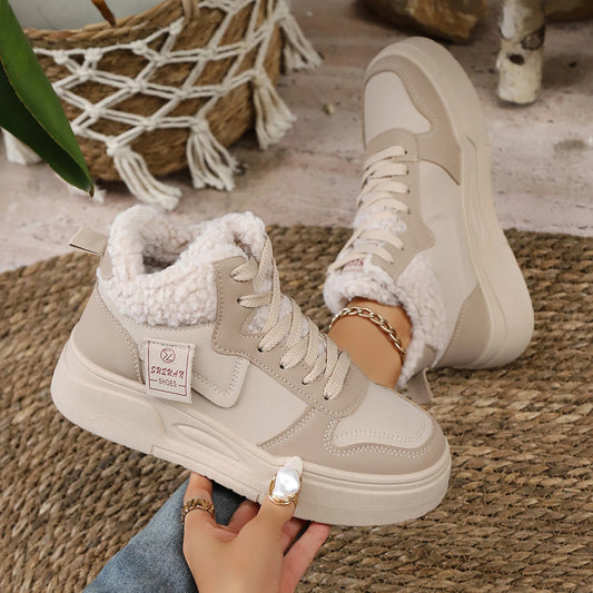 Beige high-top sneakers with white fur lining worn by a person on a woven mat.