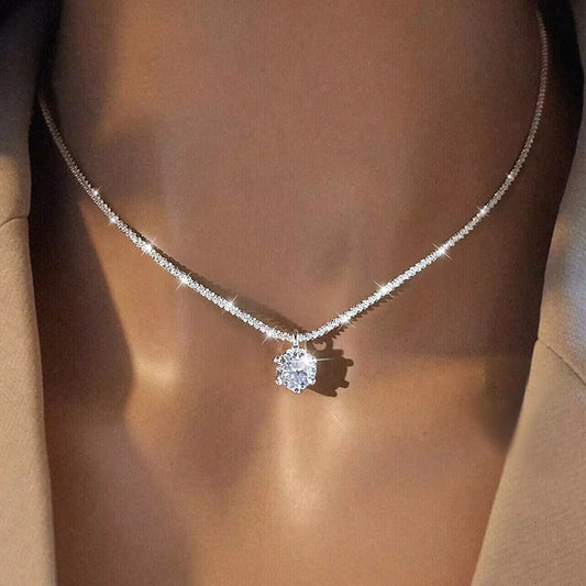 Diamond necklace on a person wearing a beige top