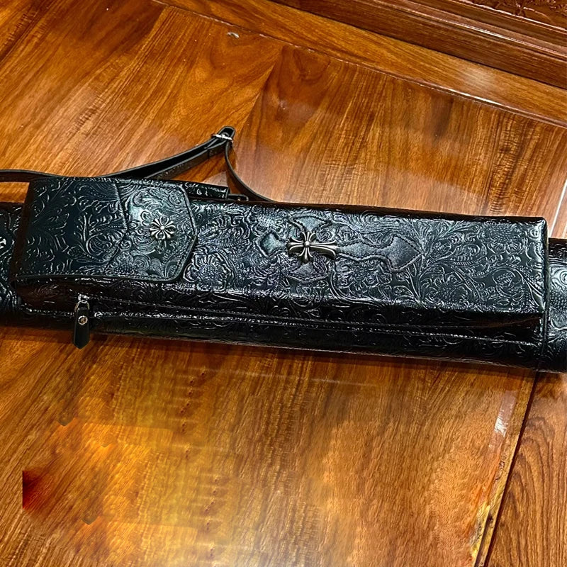 Decorative black leather case with intricate patterns on a wooden floor
