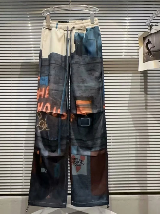 Colorful patterned pants on a hanger against a striped wall.