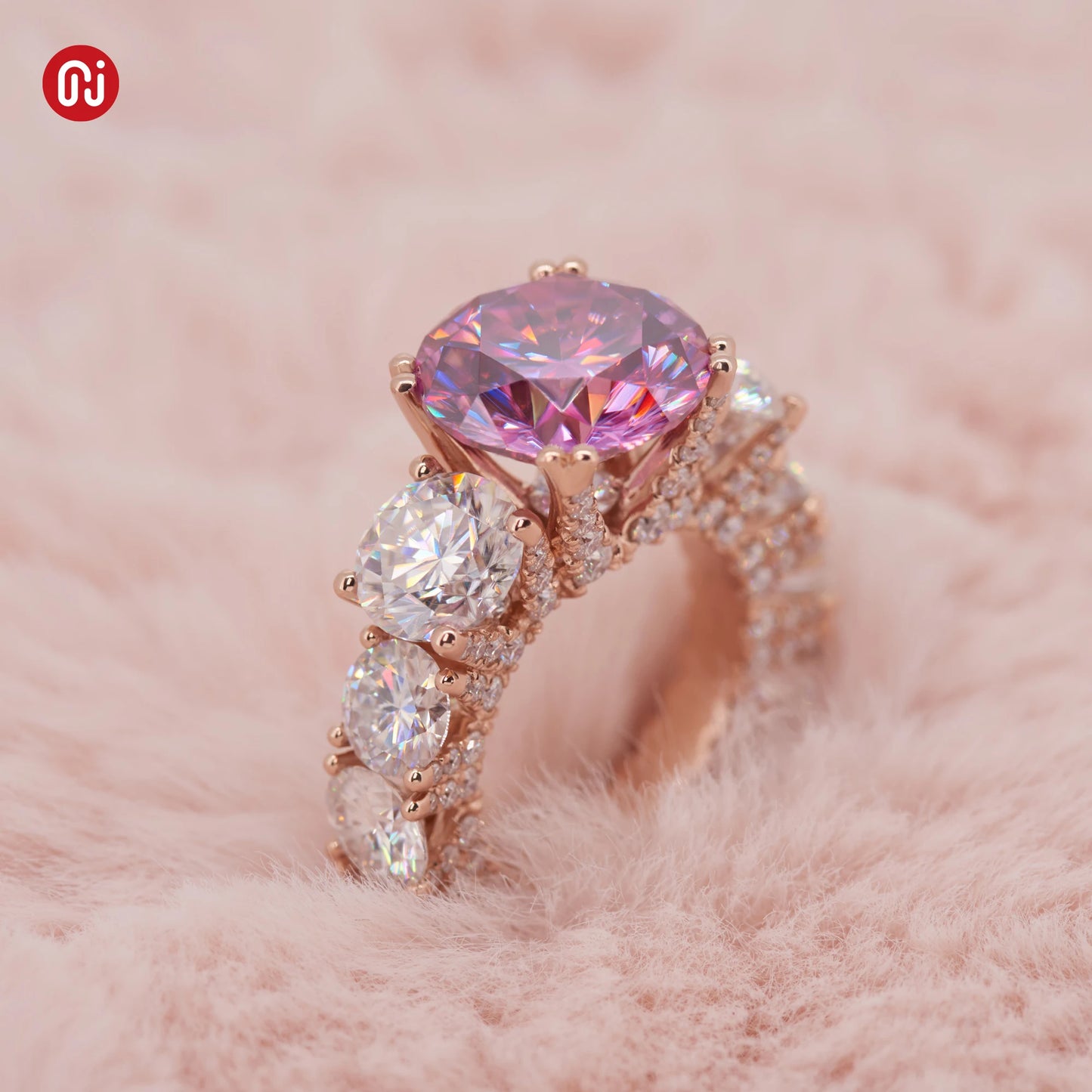 Rose gold ring with pink gemstone on a pink fur background