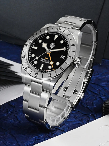 Silver watch with black dial on a blue textured surface