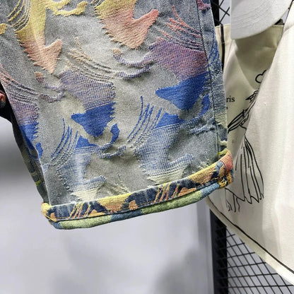 Close-up of a denim jacket with colorful embroidery on a white background