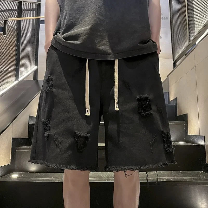 Person wearing black distressed shorts and a dark shirt on a staircase.
