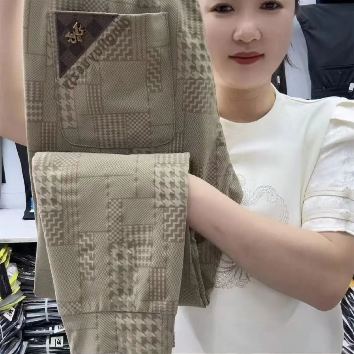Woman holding a folded patterned fabric in a store setting