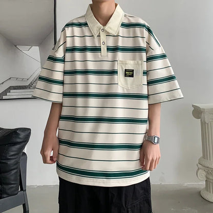 Person wearing a beige and green striped polo shirt in an indoor setting.