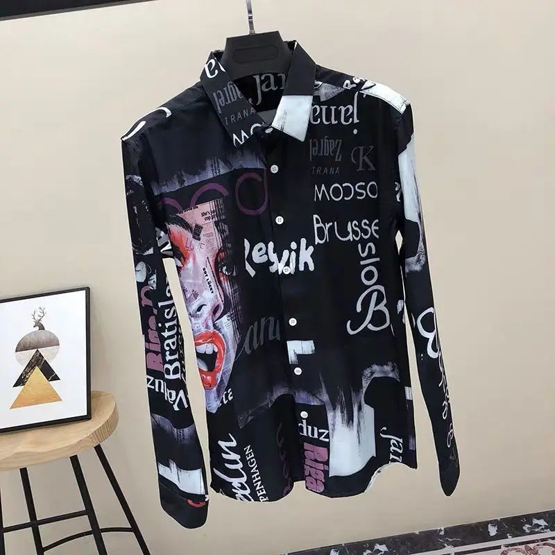 Black shirt with graphic designs and text on a hanger against a beige wall.
