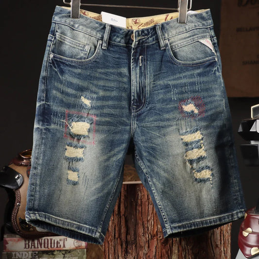 Distressed blue denim shorts on a wooden surface with a dark background