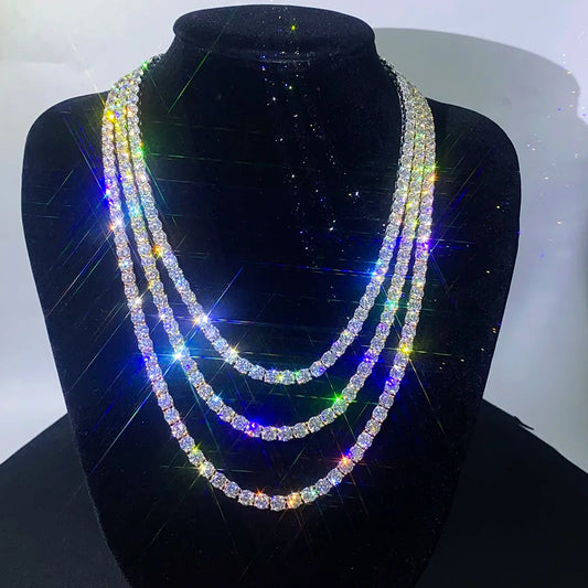 A three-strand rhinestone chain necklace displayed on a black velvet jewelry bust. The necklace features clear cubic zirconia stones that reflect a rainbow of colors under bright, high-contrast lighting, creating starburst effects.