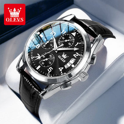 Black wristwatch with silver accents on a white cushion, brand 'OLEVS' visible.