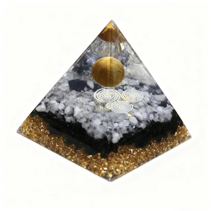 Pyramid-shaped object with gold and black design on a white background