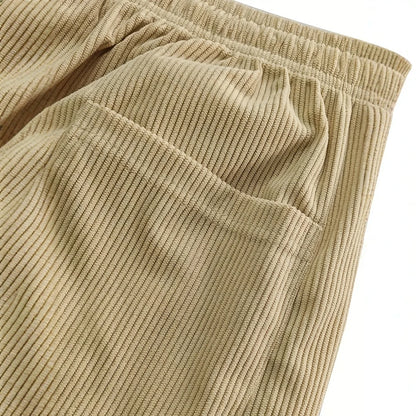 Close-up of beige corduroy pants with an elastic waistband on a white background