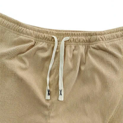Beige corduroy pants with drawstring on a white background