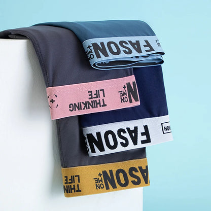 Stack of folded pants with visible branding on a light blue background