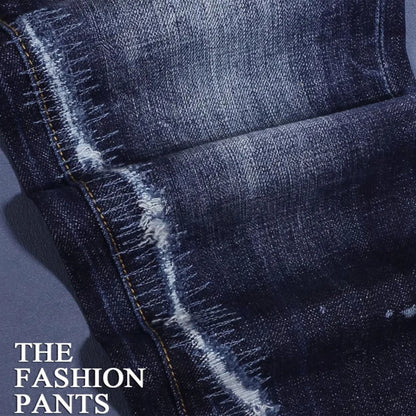 Close-up of blue denim fabric with 'The Fashion Pants' text.