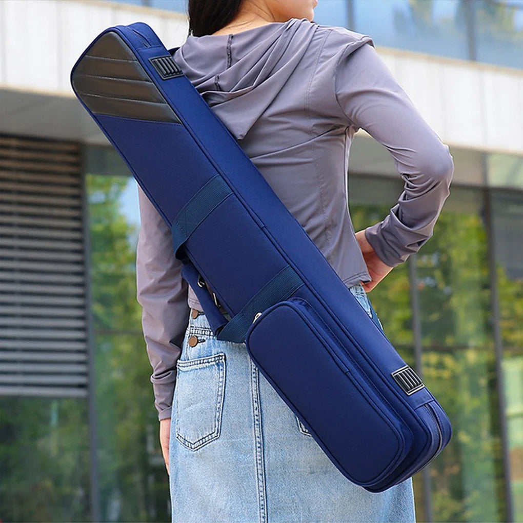 Person carrying a blue guitar case over their shoulder outdoors.