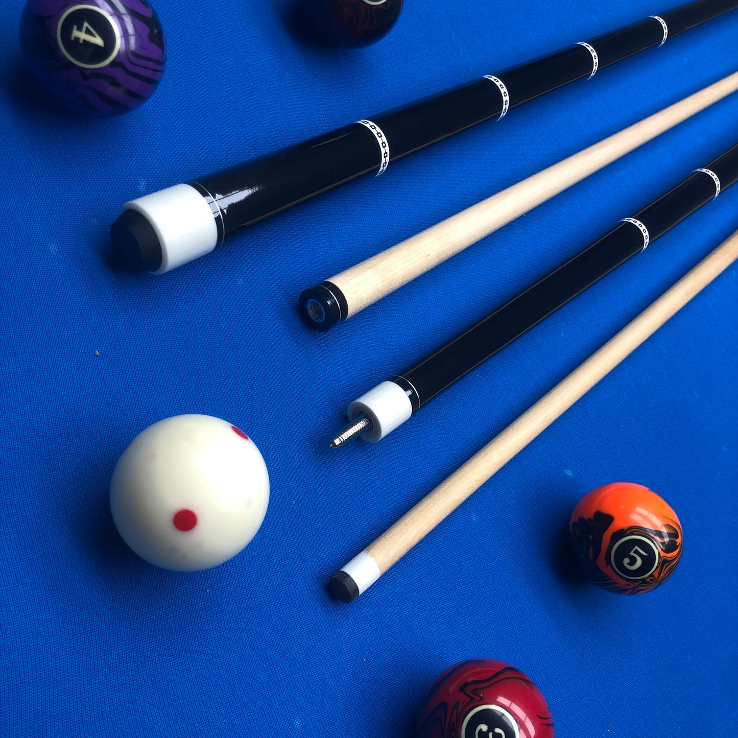 Pool cues and balls on a blue felt surface