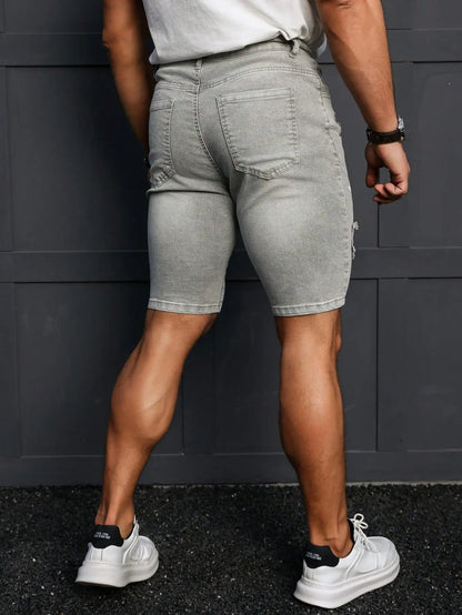 Person wearing gray shorts and white sneakers against a dark background
