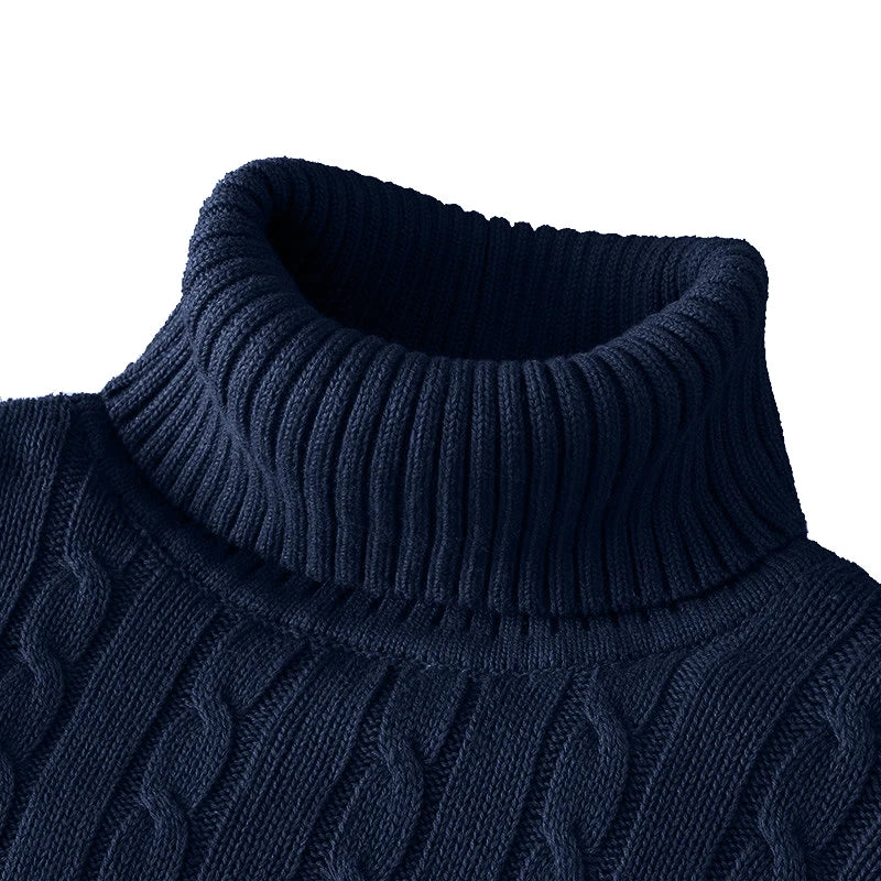 Close-up of a navy blue cable knit sweater with a ribbed collar on a white background