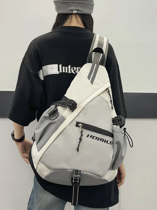 Person wearing a gray and white sling bag with visible branding.