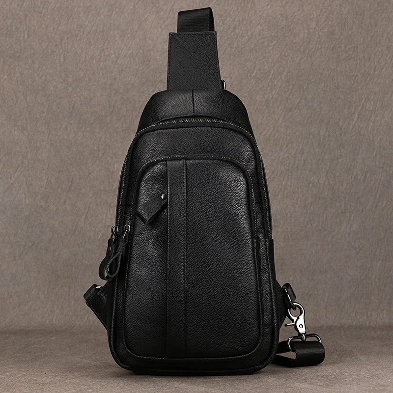 Black leather sling bag on a gray background