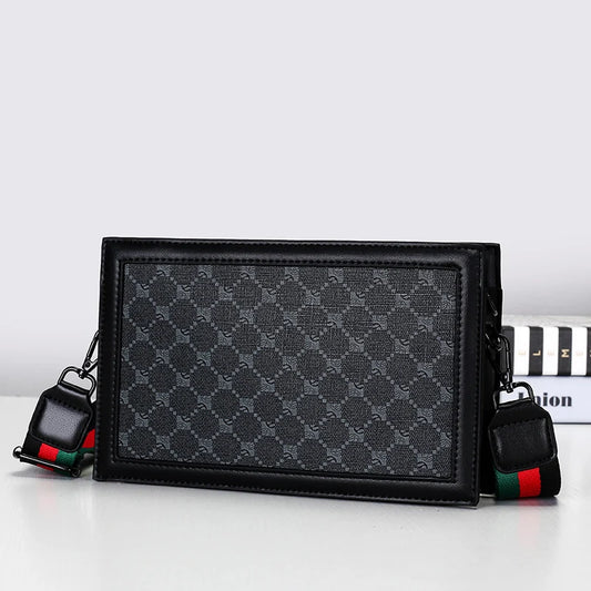 Black patterned handbag with colorful strap on a white background