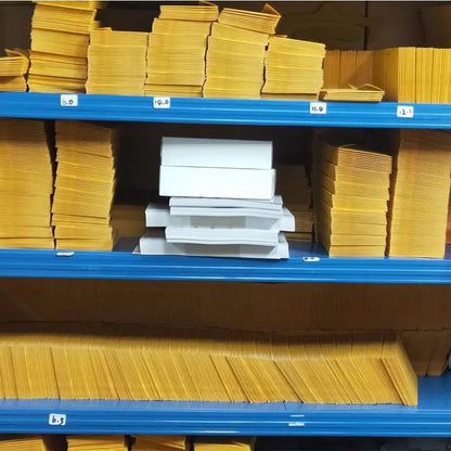 Shelves with stacks of yellow and white boxes in a storage area.