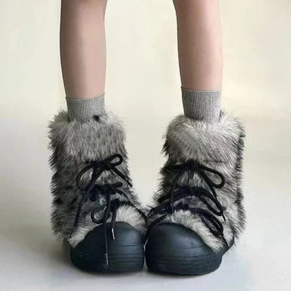 Black shoes with gray fuzzy tops worn with gray socks on a plain background