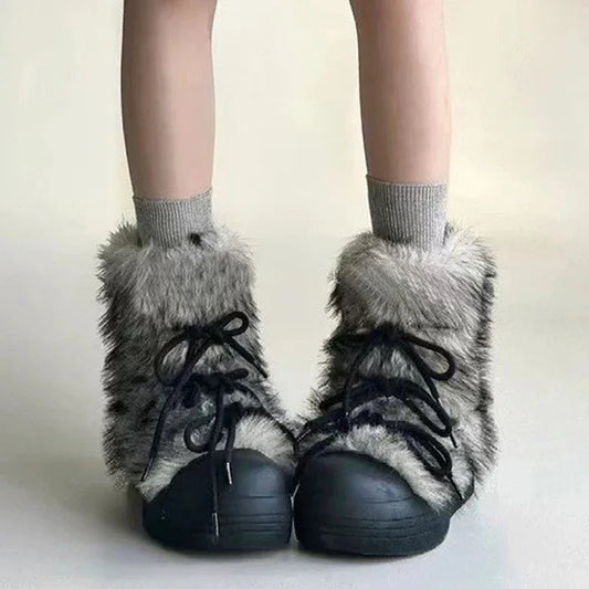 Black shoes with gray fuzzy tops worn with gray socks on a plain background