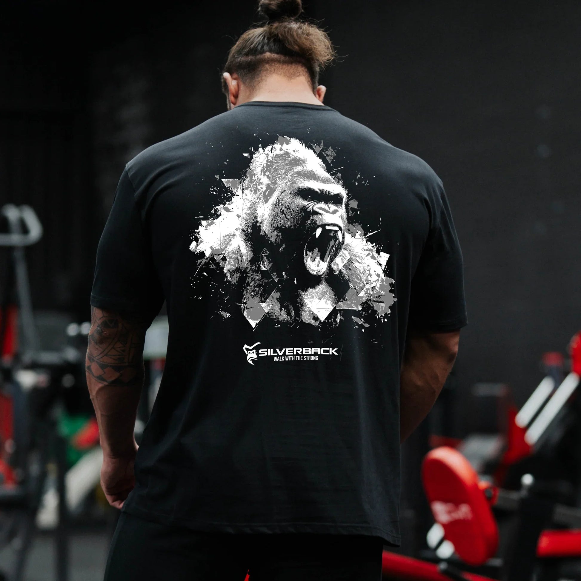 Person wearing a black t-shirt with a gorilla graphic and 'Silverback' logo in a gym setting.