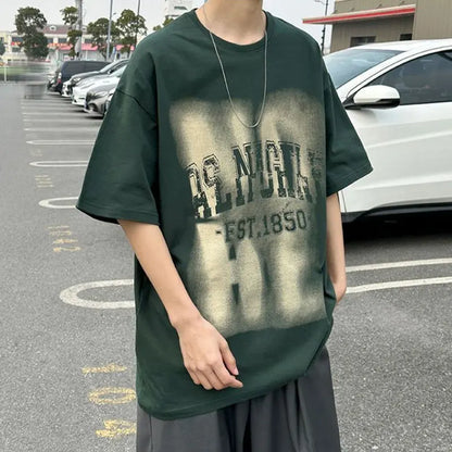 Person wearing a green t-shirt with text in a parking lot