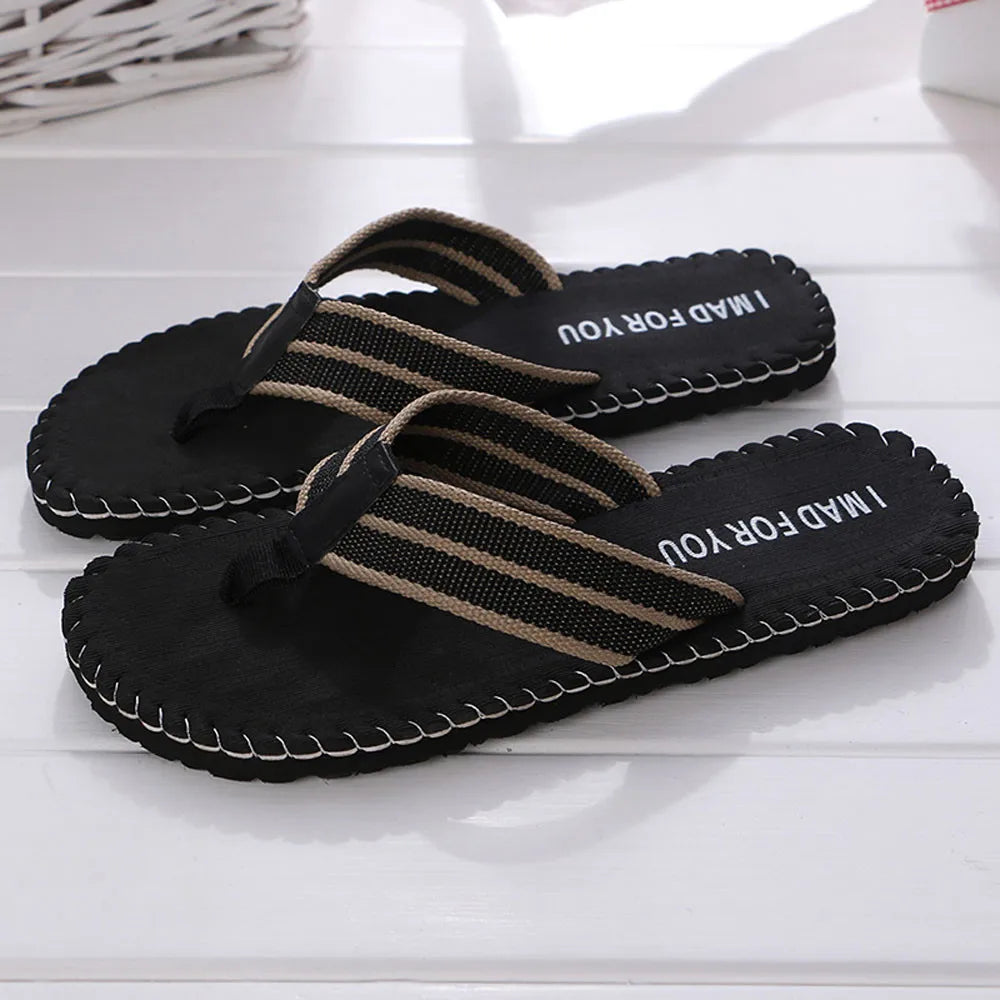 Black sandals with brown straps on a white surface
