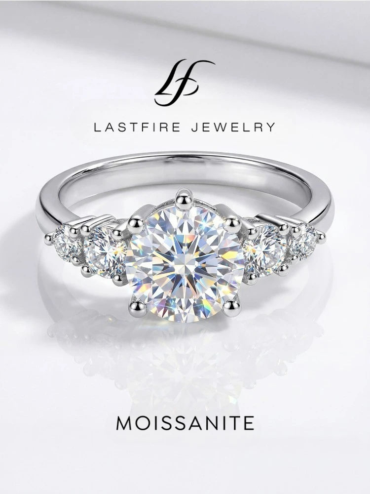 Silver ring with moissanite gemstone on a white background, featuring Lastfire Jewelry logo.
